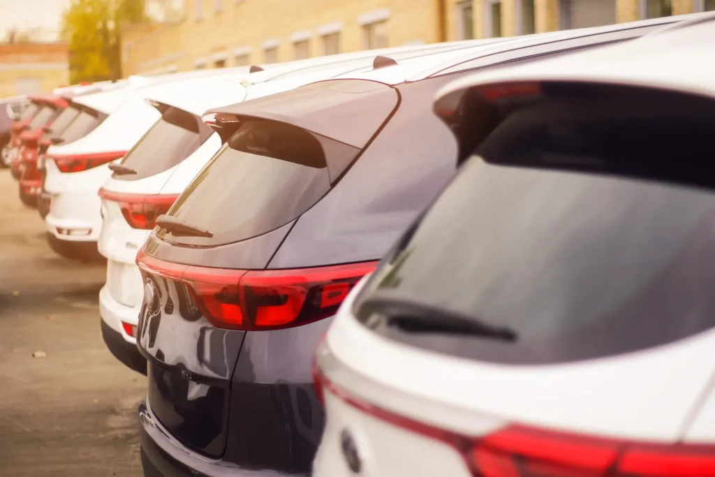Row of white and grey fleet vehicles parked together, ready for sale through fleet vehicle disposal